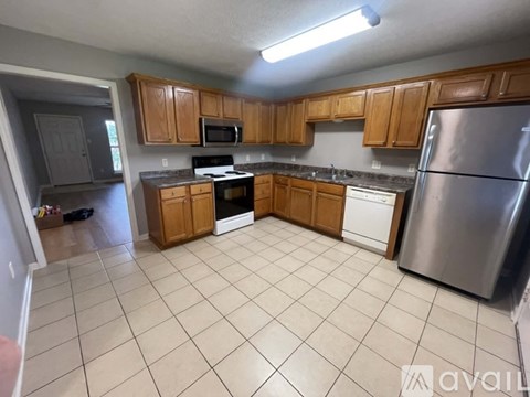 A kitchen with wooden cabinets and a stainless steel refrigerator.