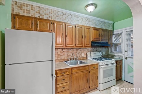 A kitchen with wooden cabinets and a white refrigerator.