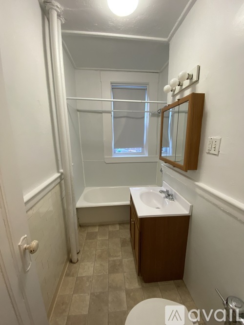 A bathroom with a white tub, sink, and a mirror.