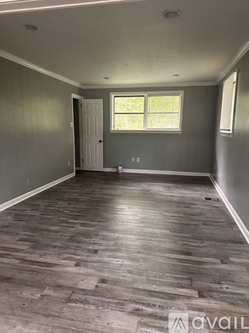 A room with wooden flooring and a window.