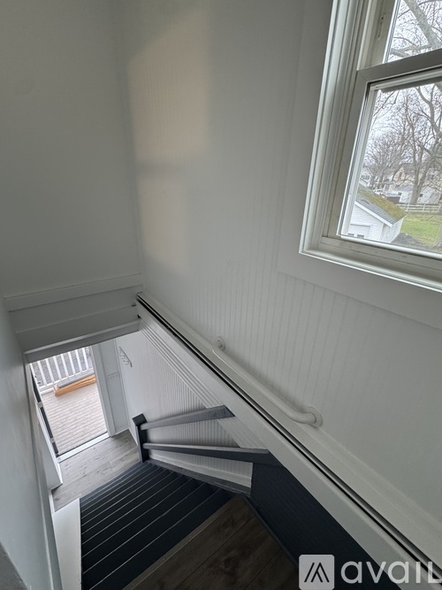 A view from the top of a staircase looking down to a doorway.