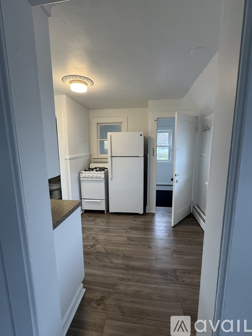 A kitchen with a white fridge and a window.