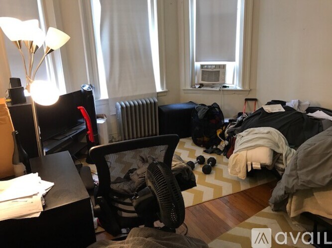 A messy room with a bed, chair, and scattered items.
