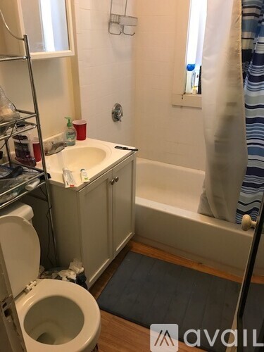 A bathroom with a toilet, sink, and bathtub.