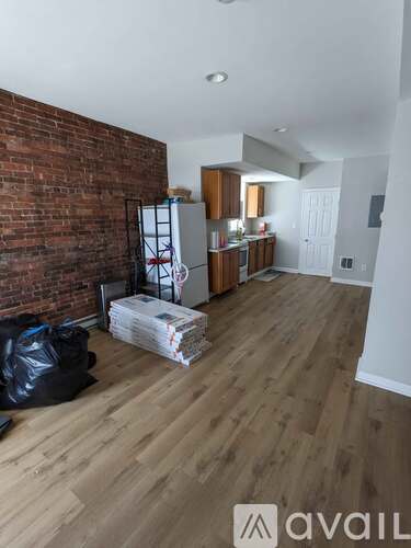 A room with a brick wall and wooden flooring.
