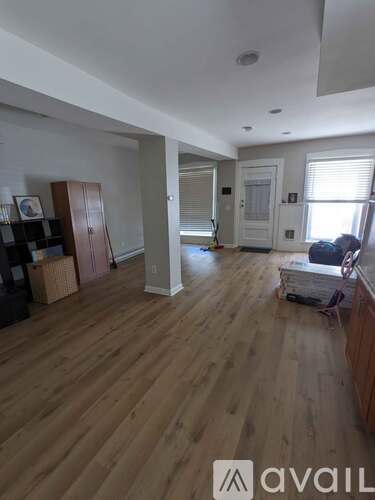 A room with wooden floors and a cabinet in it.