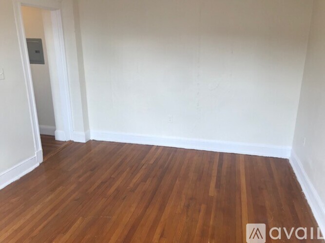 A room with wooden flooring and white walls.