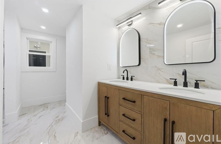 A bathroom with a marble floor and wooden cabinets.