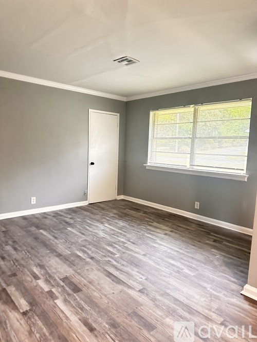 A room with a wooden floor and a white door.