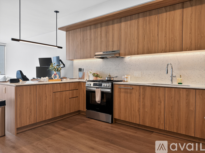 A modern kitchen with wooden cabinets and a stainless steel oven.