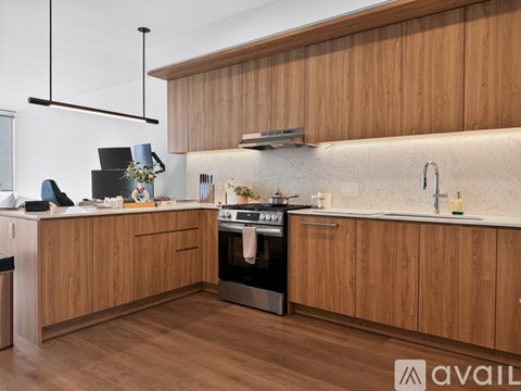 A modern kitchen with wooden cabinets and a stainless steel oven.