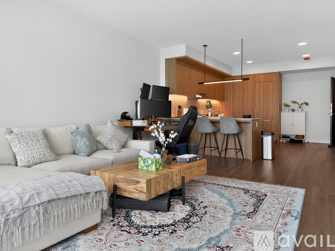 A living room with a grey couch, a wooden coffee table, and a rug.