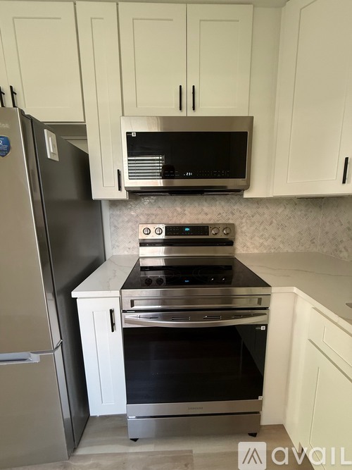 A kitchen with a black microwave above a stove and a black oven below it.