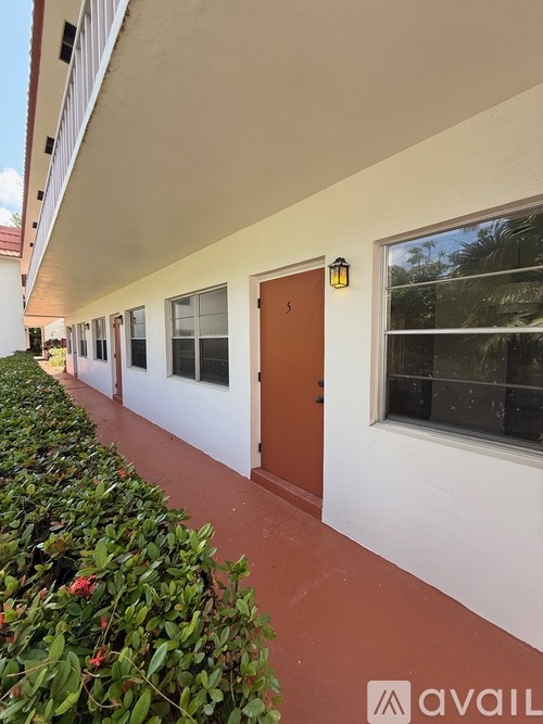 A building with a red door and windows on the side.