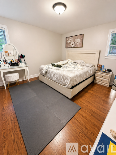 A bedroom with a bed, dresser, and window.