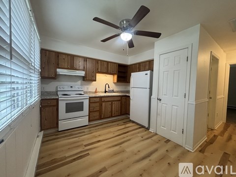 A kitchen with wooden cabinets and a white refrigerator.