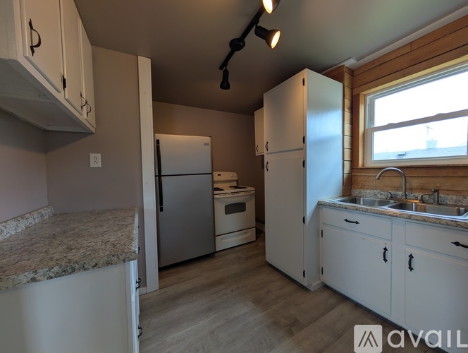 A kitchen with white cabinets and a granite countertop.