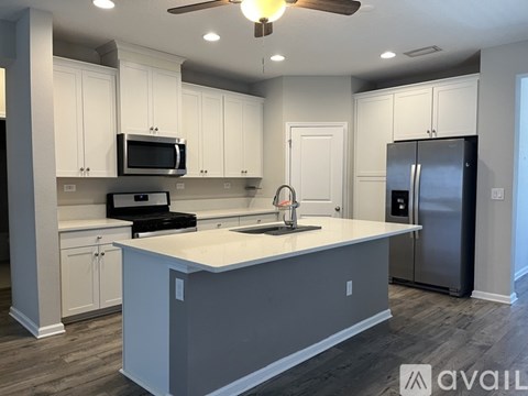 A kitchen with white cabinets and a central island.