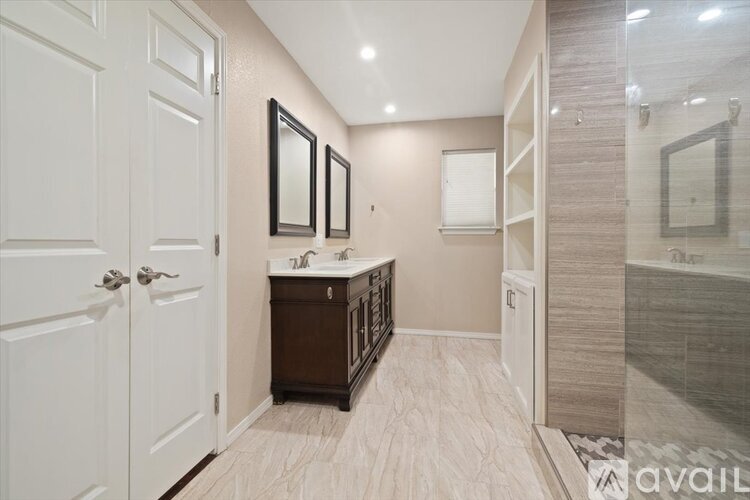 A bathroom with a sink, mirrors, and a shower.