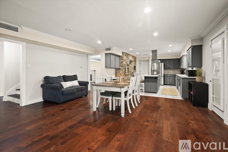 A living room with a grey couch and a wooden floor.