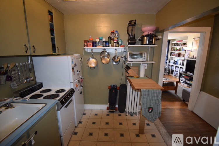 A kitchen with a white stove top oven and a white refrigerator.