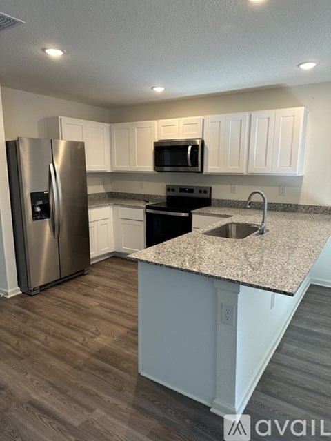 A kitchen with a granite countertop and stainless steel appliances.