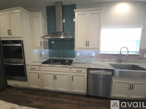 A kitchen with white cabinets and a stainless steel dishwasher.