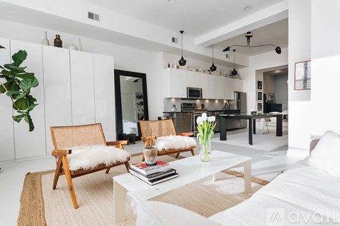 A modern living room with a white couch and a wooden chair.