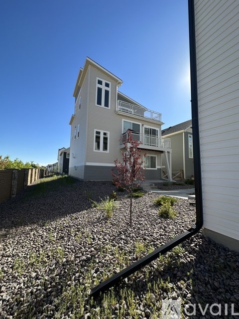 A house with a gravel driveway and a tree in front.