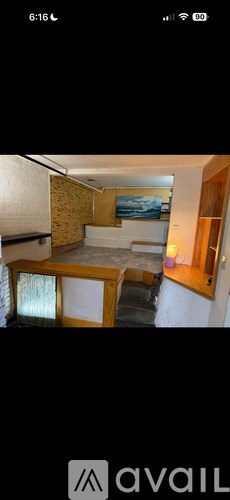 A room with a bed and a painting on the wall.