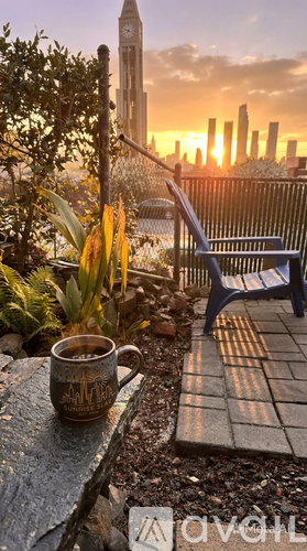 A mug with the word "MARTINI" on it sits on a table next to a blue chair.