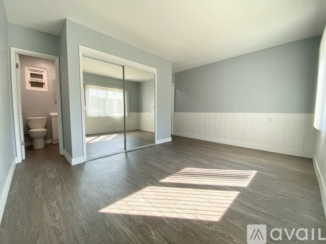 A spacious room with a sliding glass door leading to a balcony.
