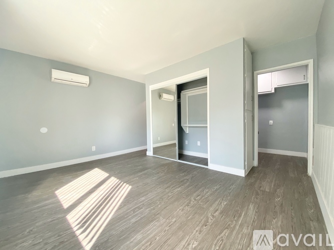 A room with a wooden floor and a white door.