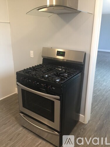 A modern stove with a digital clock on the front is in a kitchen.