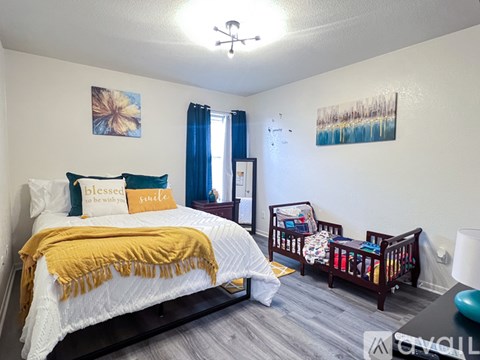 A bedroom with a white bed and a yellow blanket.