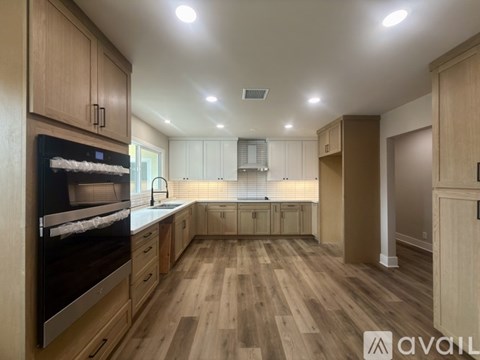 A kitchen with wooden cabinets and a refrigerator.