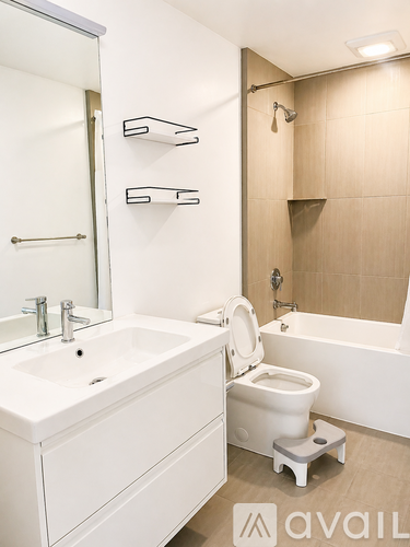 A white bathroom with a toilet, sink, and bathtub.