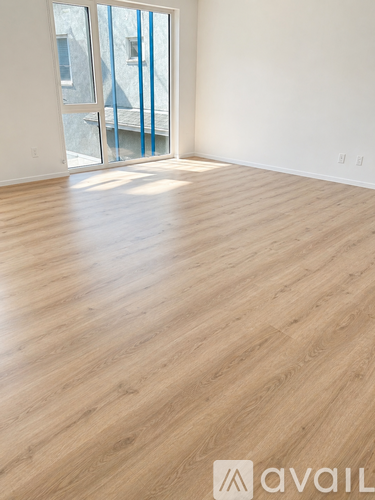 A room with wooden flooring and a sliding glass door.