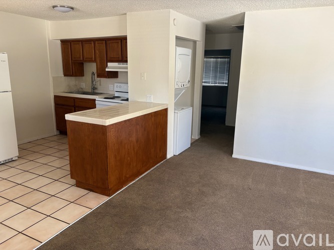 A kitchen with white appliances and brown cabinets.