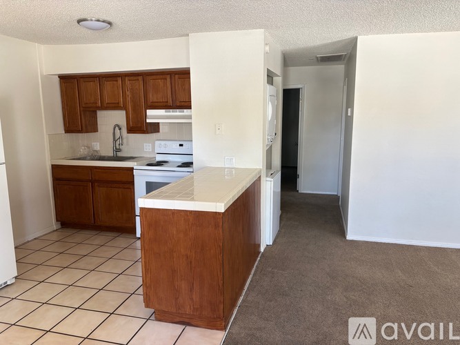 A kitchen with white appliances and wooden cabinets.