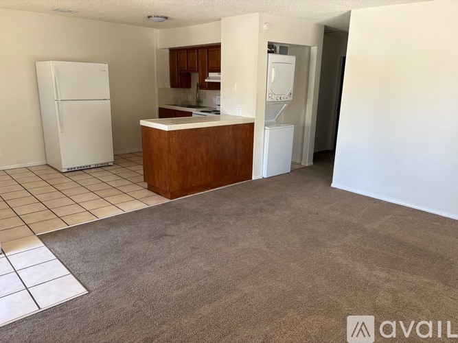 A kitchen area with a white refrigerator and a brown counter.