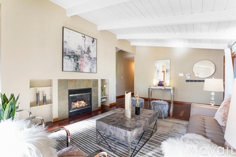 A living room with a fireplace and a painting on the wall.