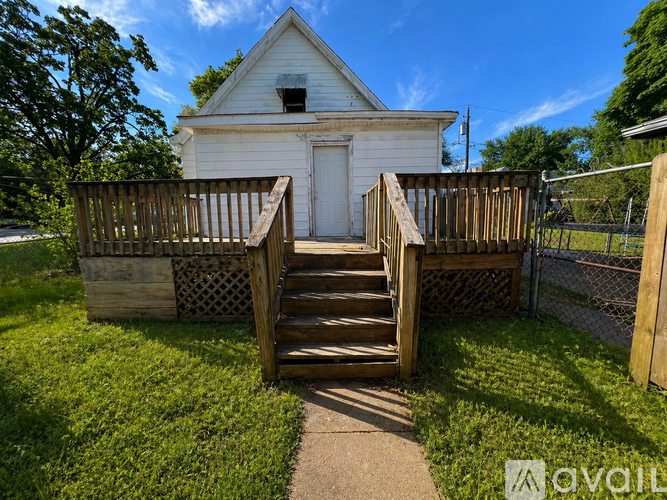 A white church with a wooden staircase leading to the door.