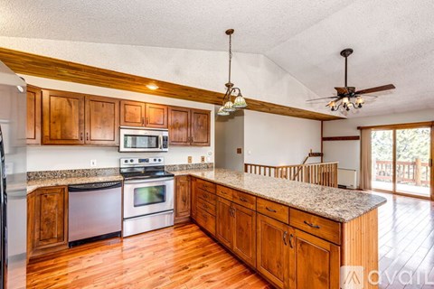 A kitchen with wooden cabinets and a granite countertop.