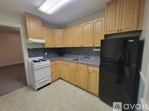 A kitchen with black appliances and wooden cabinets.