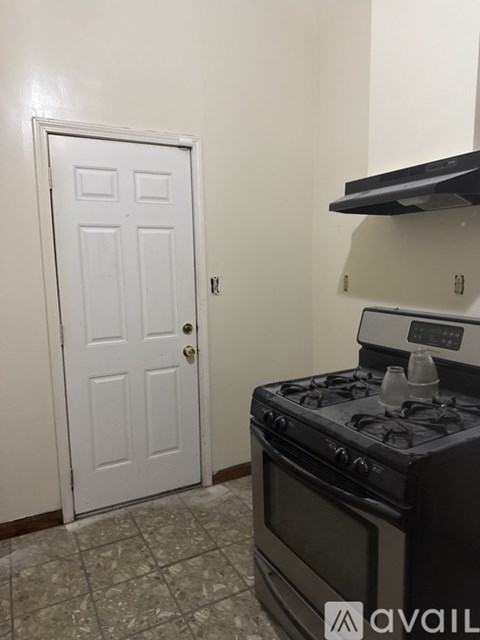A black stove top oven in a kitchen with a white door.
