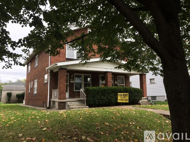 A house with a "For Rent" sign in front.