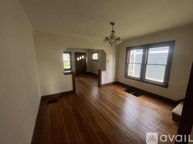 A room with wooden floors and a chandelier.