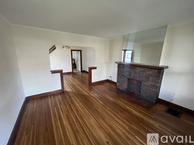 A room with wooden floors and a fireplace.