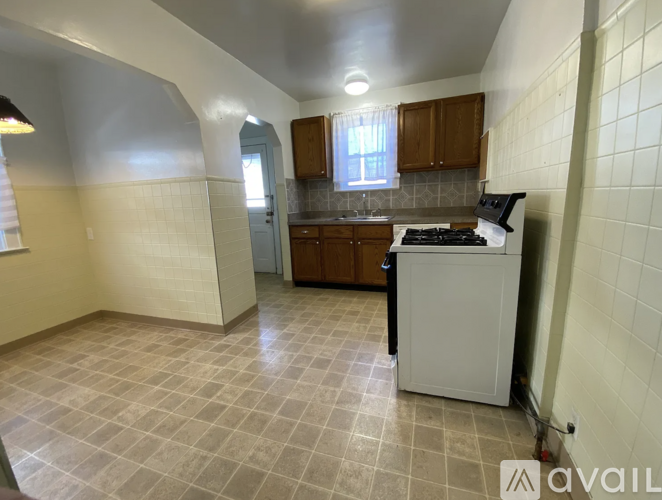 A kitchen with a white dishwasher and a tile floor.